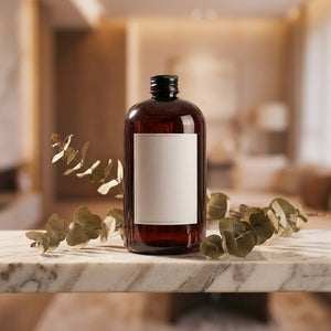 Flacon d'huile parfumée pour diffuseur à roseaux posé sur un plateau en marbre