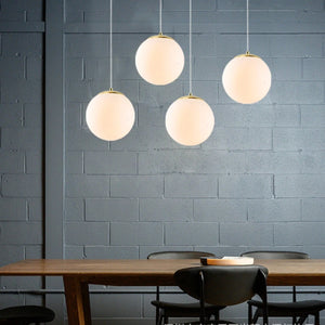 Suspensions boules de verre dorées dans une salle à manger au mur de brique