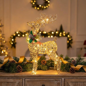 Renne de Noël doré en fil de métal sur meuble bois avec branches de sapin