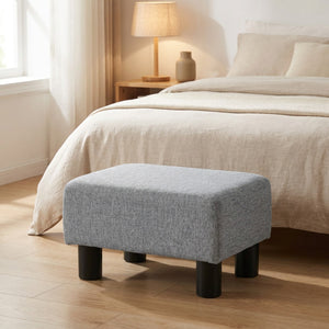 Repose-pieds gris au pied d un lit dans une chambre chaleureuse