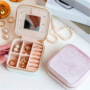 Boîte à bijoux de voyage ouverte avec bijoux dorés intérieur beige velours rose