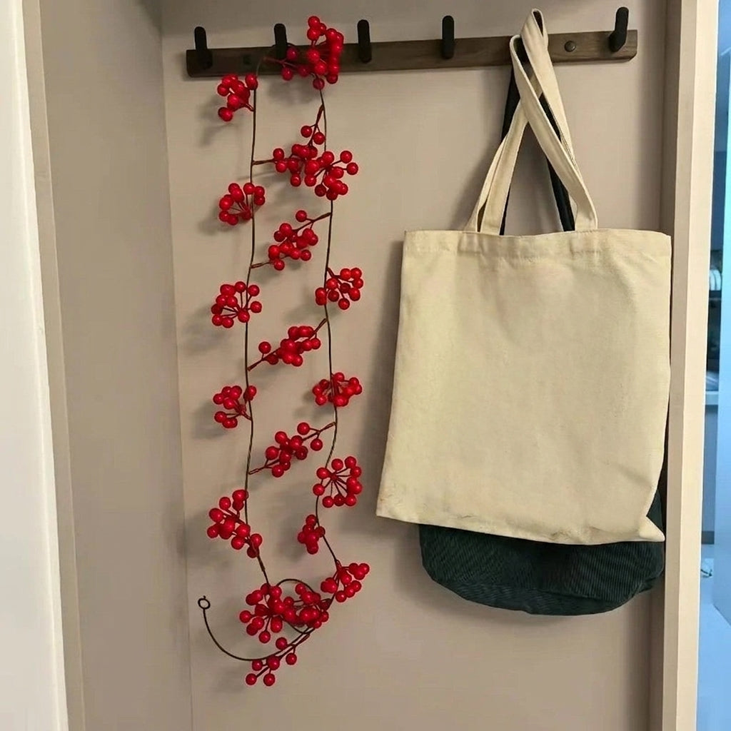 Vigne de canneberge suspendue à une patère d'entrée à côté d'un sac en toile
