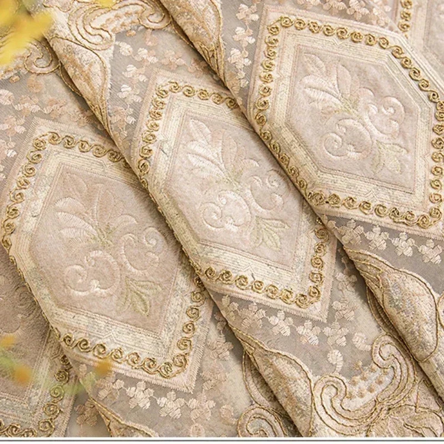 Détail du tissu chenille brodé de motifs damassés dorés et de fines perles