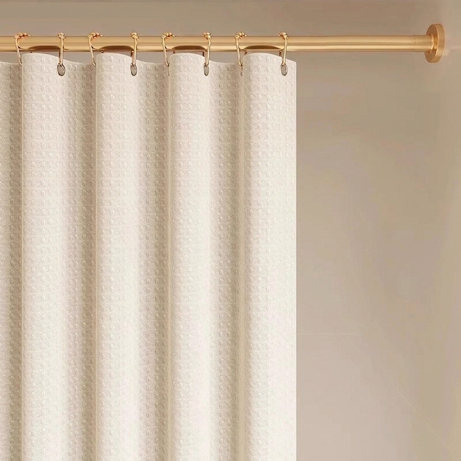 Rideau de douche suspendu par des crochets sur une tringle dorée