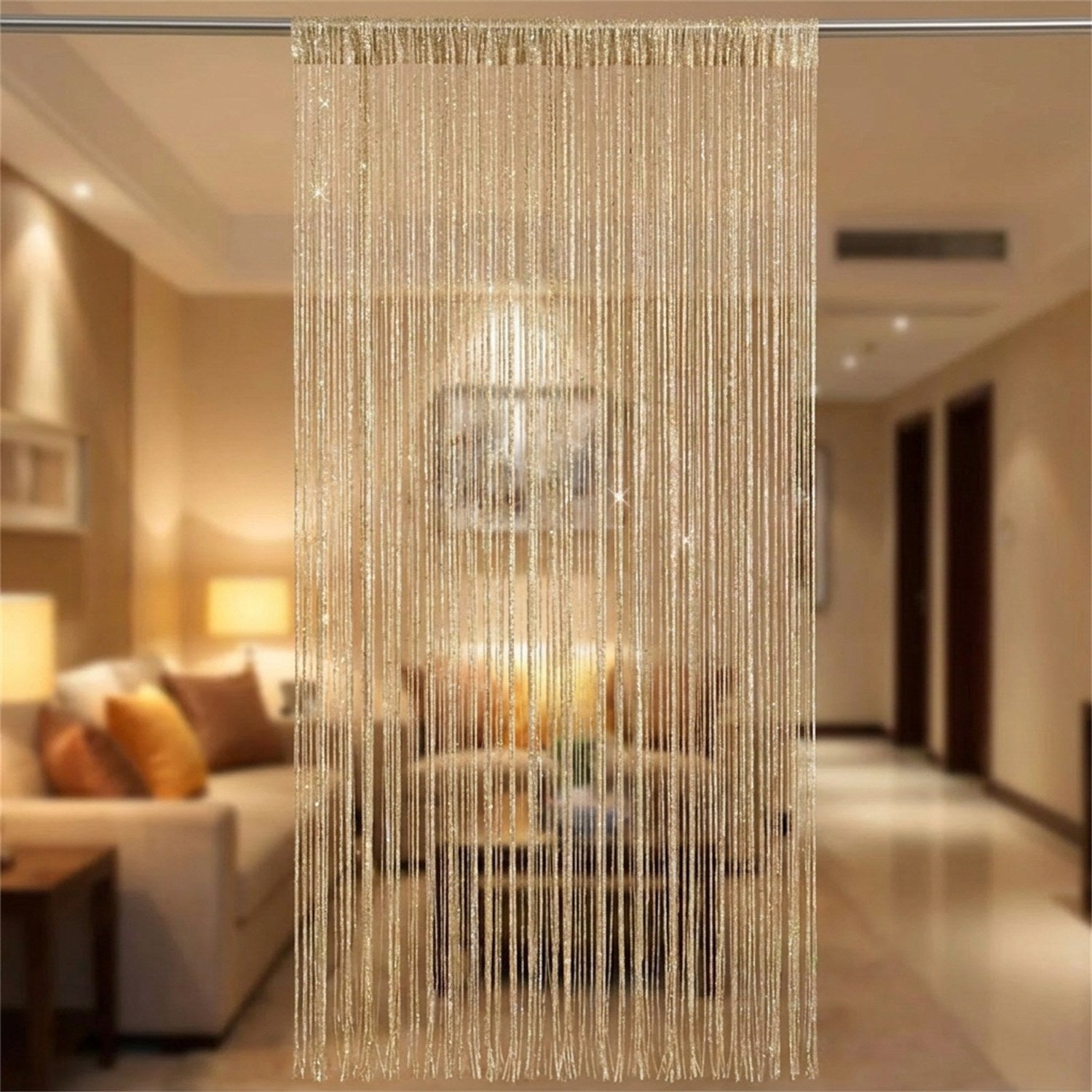 Rideau de fils à paillettes champagne en séparation de pièce dans un salon chaleureux