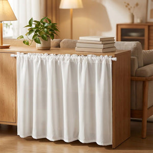 Rideau de meuble blanc posé sur un buffet en bois dans un salon chaleureux