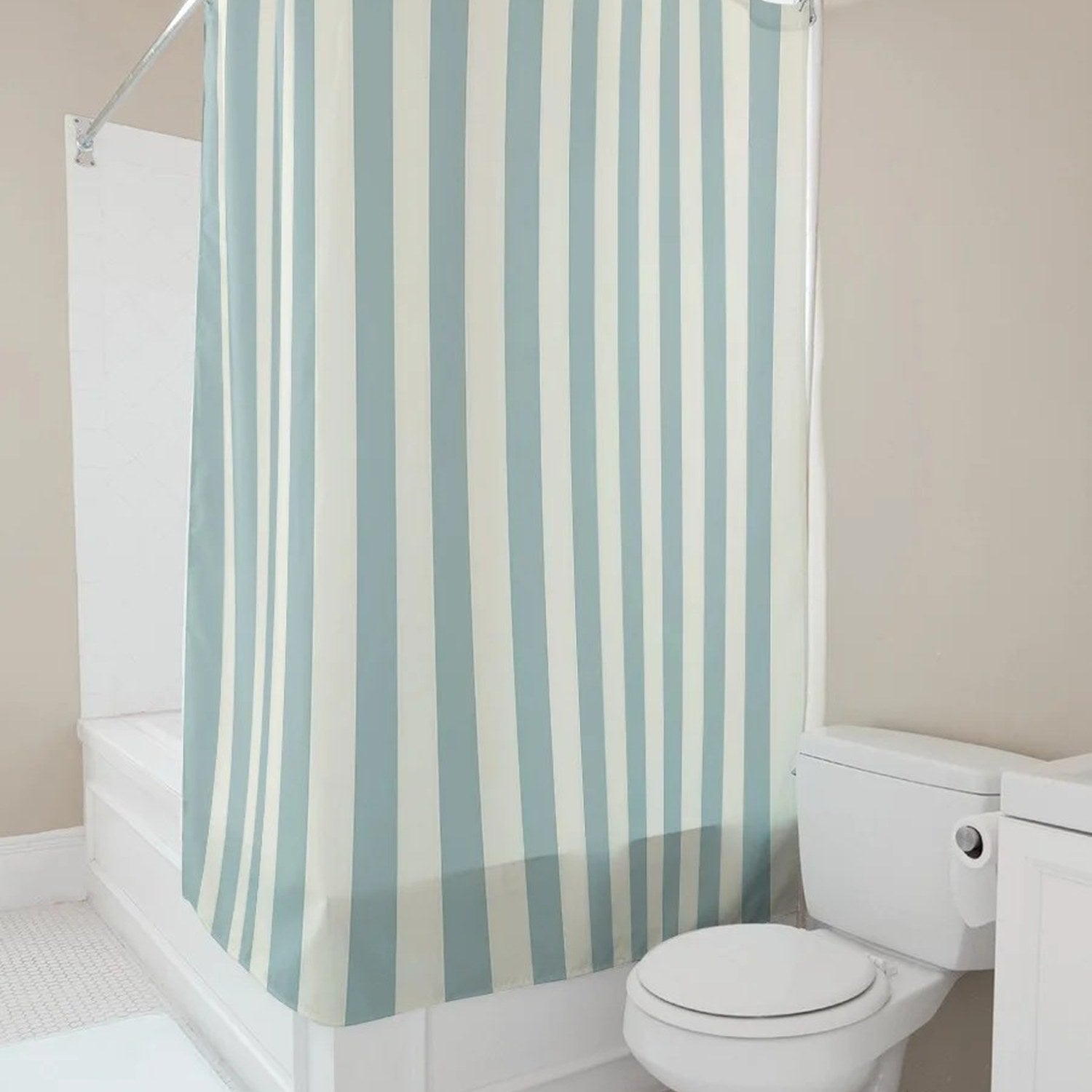Rideau de douche rayé installé en angle au-dessus d'une baignoire