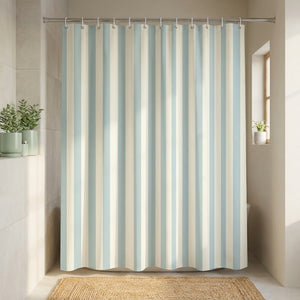 Rideau de douche rayé bleu clair autour d'une cabine de douche dans une salle de bain zen
