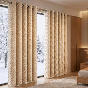 Rideau thermique occultant beige à motif chevrons suspendu devant une fenêtre enneigée