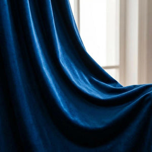 Plis généreux du velours bleu roi capturant la lumière douce d'une fenêtre