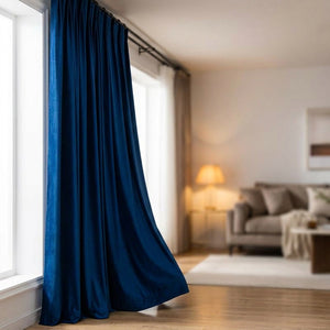 Rideau en velours bleu roi profond suspendu devant une fenêtre de salon lumineux