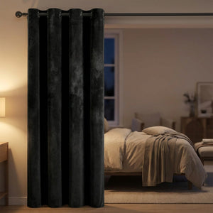 Rideau en velours noir devant une fenêtre de chambre avec lampe de chevet