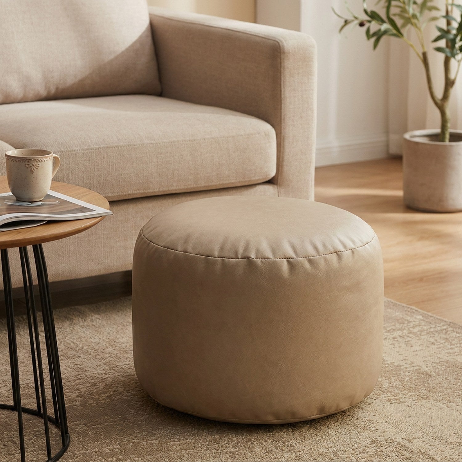 Pouf ottoman rond en simili cuir beige rembourré dans un salon chaleureux