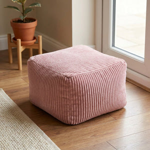 Tabouret pouf rose en velours côtelé posé au sol