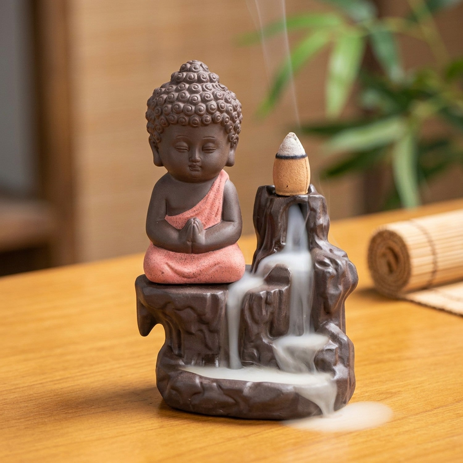 Brûleur d'encens à reflux en céramique avec petit moine bouddha à la robe rose et cascade de fumée