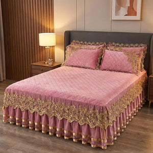 Couvre-lit en velours rose à broderie dorée et jupe en dentelle sur un lit