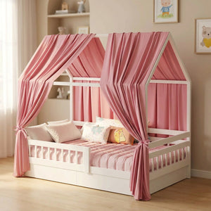 Ciel de lit cabane en mousseline rose poudré drapé sur un lit cabane blanc