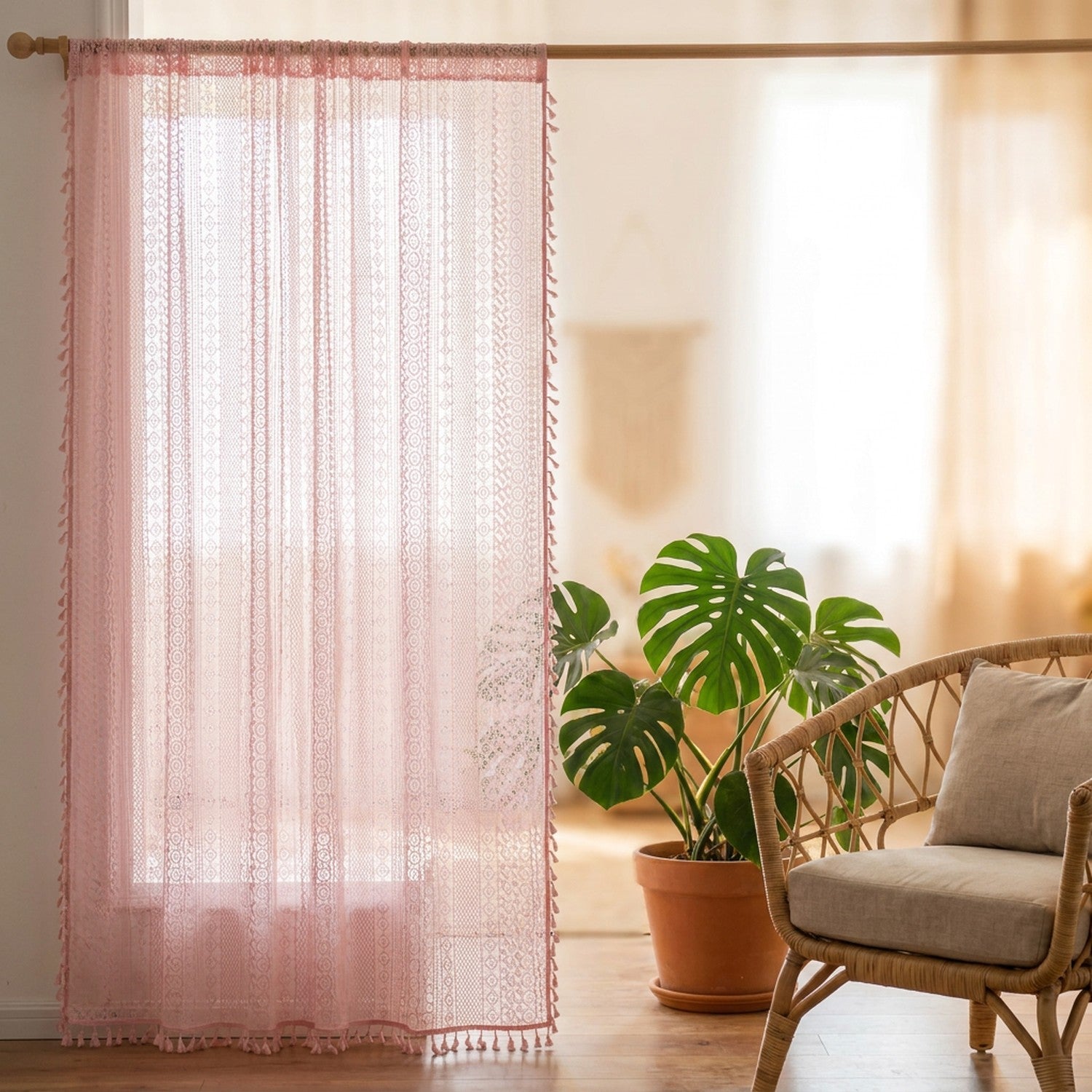 Rideau voilage boho en dentelle au crochet rose à pompons suspendu à une fenêtre