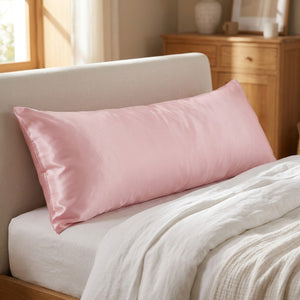 Taie d'oreiller traversin en satin rose sur un lit
