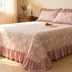 Couvre-lit matelassé à volants coloris rose sur un lit