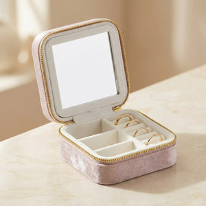 Boîte à bijoux de voyage en velours rose poudré ouverte avec miroir intérieur