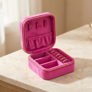 Boîte à bijoux de voyage en velours rose vif ouverte avec miroir intérieur