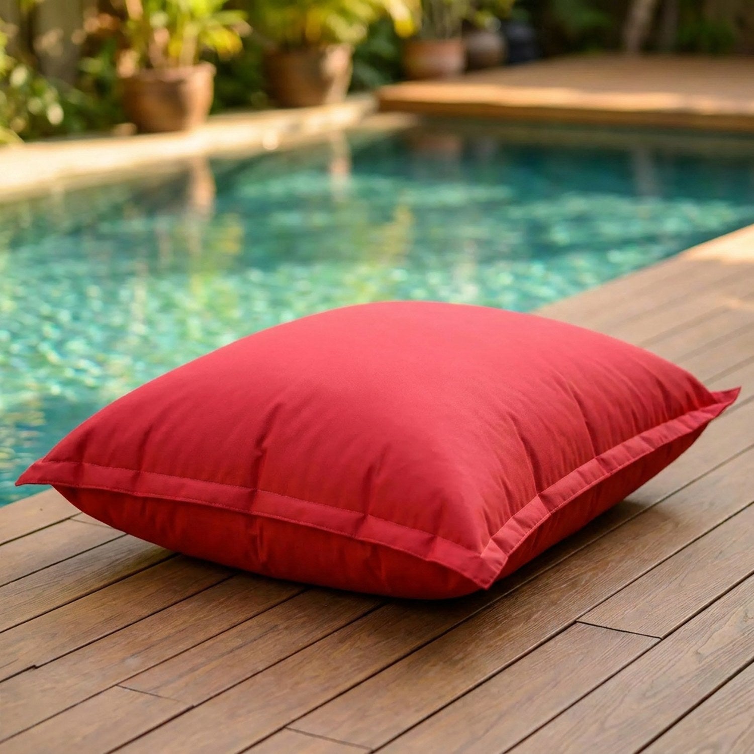 Pouf géant d'extérieur rouge au bord d'une piscine