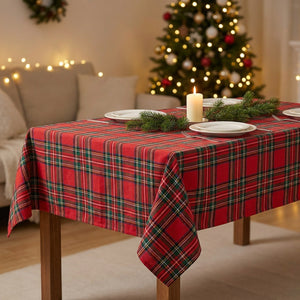 Nappe de Noël à carreaux tartan rouge dressée sur une table de fête avec bougies