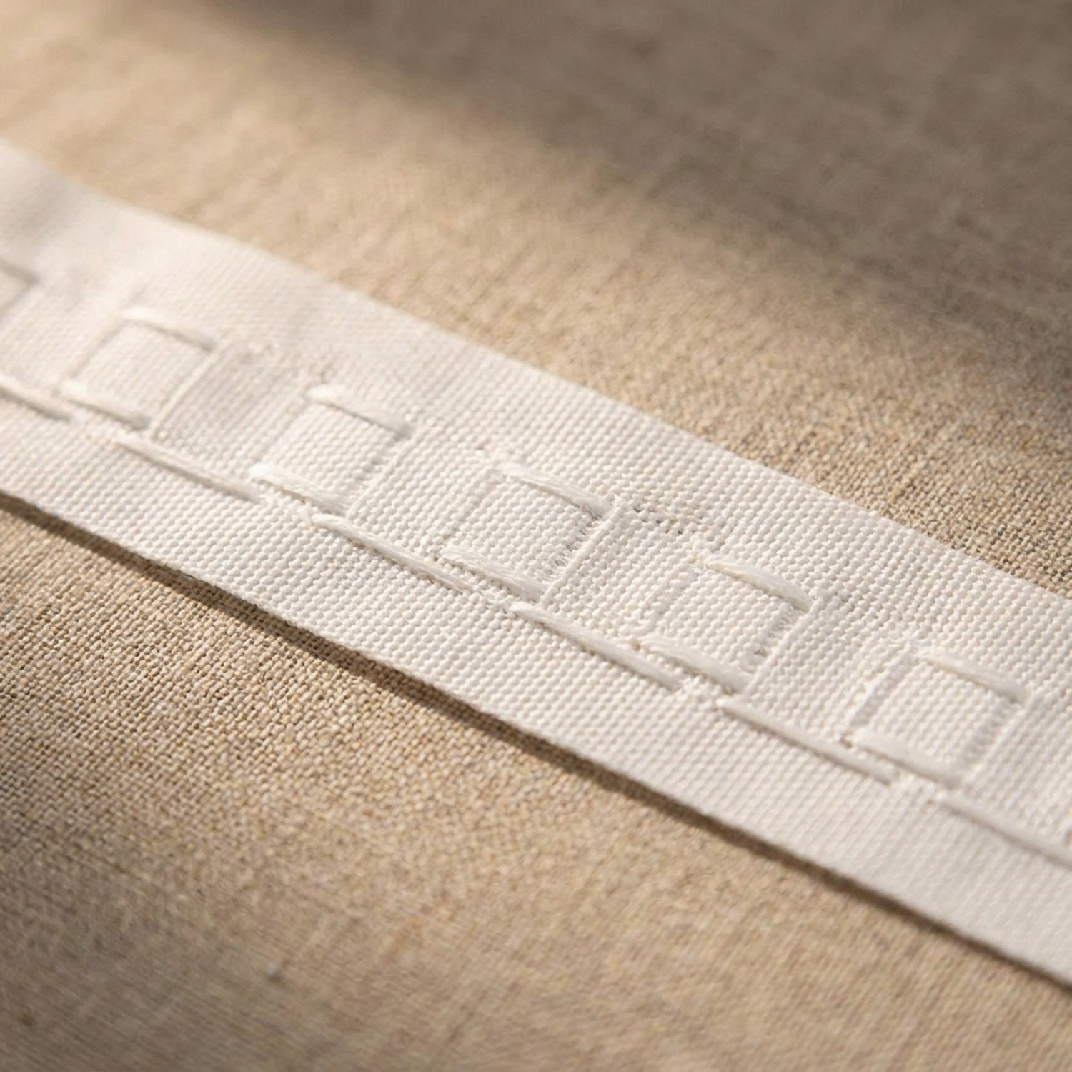Détail des poches tissées et des cordons du ruban fronceur blanc