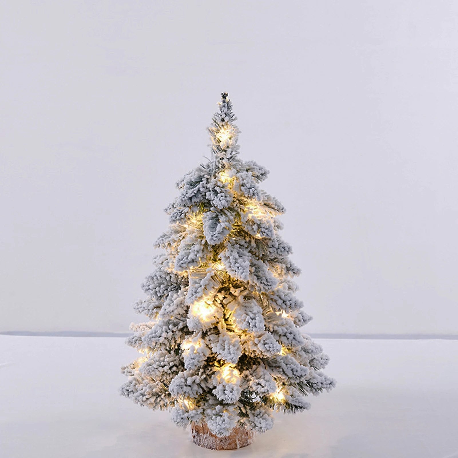 Sapin de Noël 45cm avec lumières LED allumées sur fond neutre