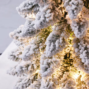 Détail des branches floquées de neige et lumières LED chaudes