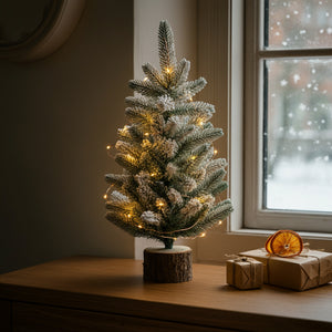 Sapin de Noël 45cm neige floquée près d'une fenêtre hivernale avec cadeaux