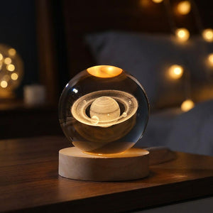 Lampe boule de cristal gravée de Saturne et ses anneaux en 3D allumée