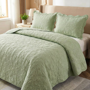 Couvre-lit matelasse vert sauge au motif damasse sur un lit avec deux taies assorties