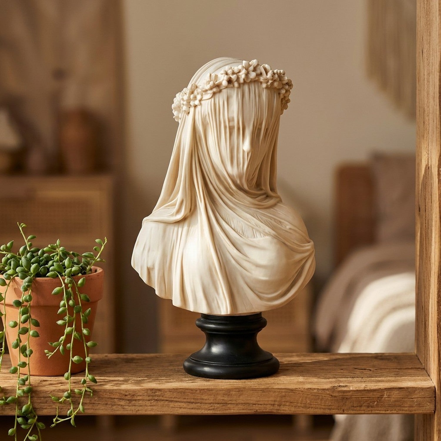 Sculpture buste voilé en résine sur étagère en bois avec plante verte décoration salon