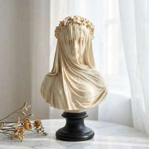 Sculpture buste voilé en résine sur surface marbre près d'une fenêtre avec voilage blanc