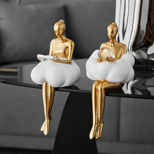 Les deux figurines femme abstraite en or sur table en verre salon contemporain