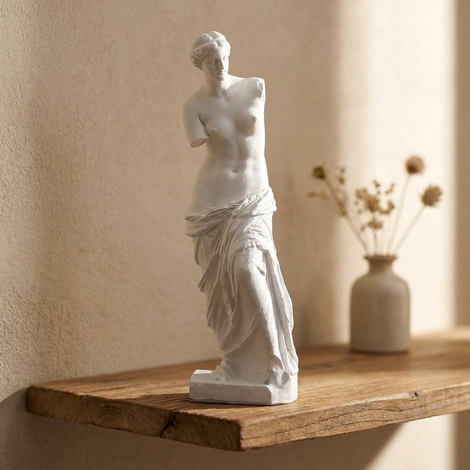 Statue de déesse grecque en résine blanche posée sur une étagère dans un salon moderne