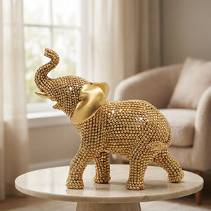 Statue éléphant doré sur une table en marbre près d'une fenêtre