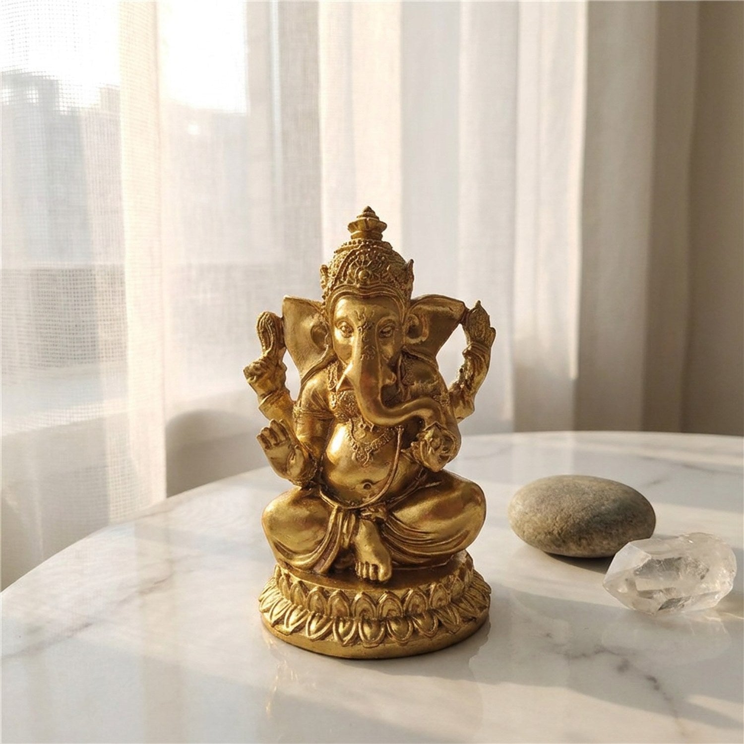 Statue Ganesha dorée posée sur un marbre blanc avec voilage blanc en arrière-plan