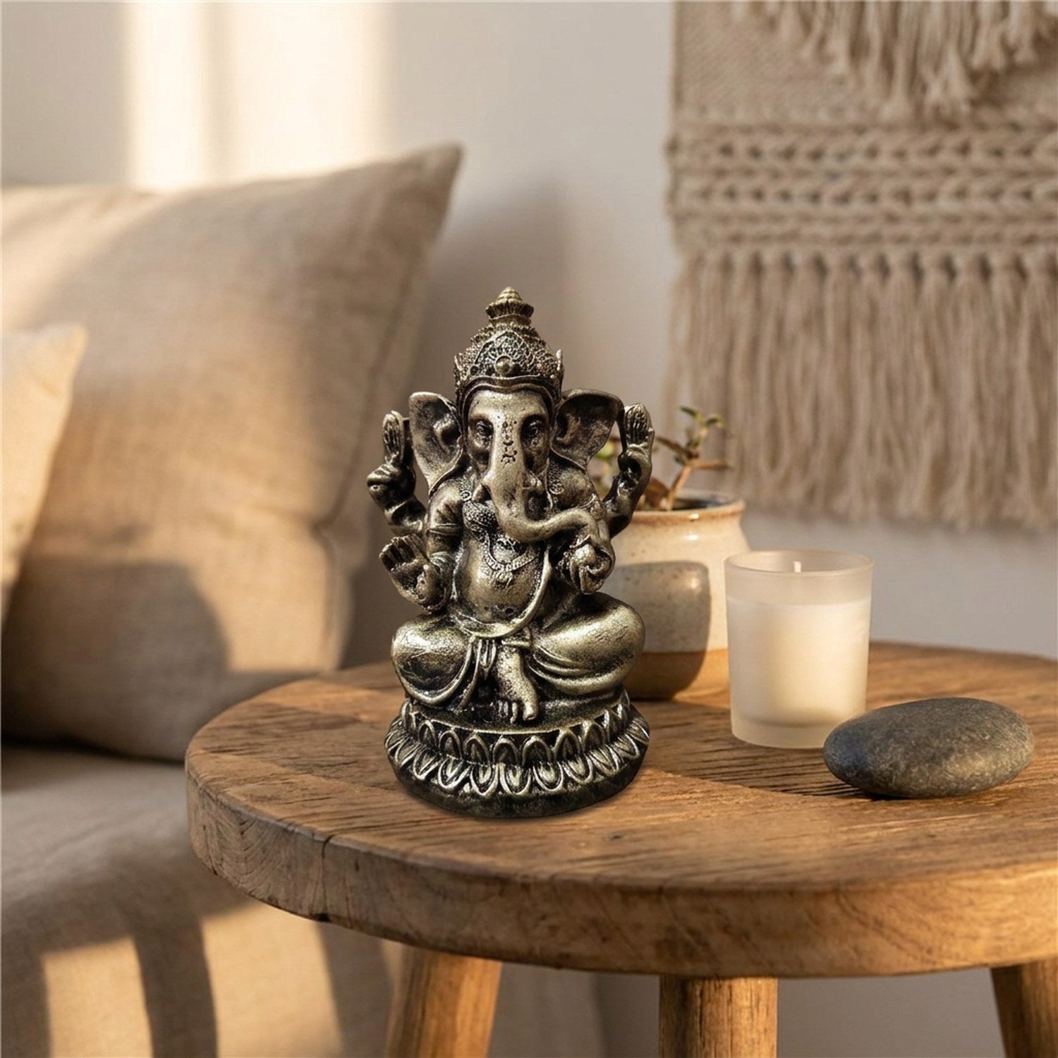 Figurine Ganesha sur une table en bois avec bougie et plante verte décoration bohème