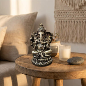 Figurine Ganesha sur une table en bois avec bougie et plante verte décoration bohème