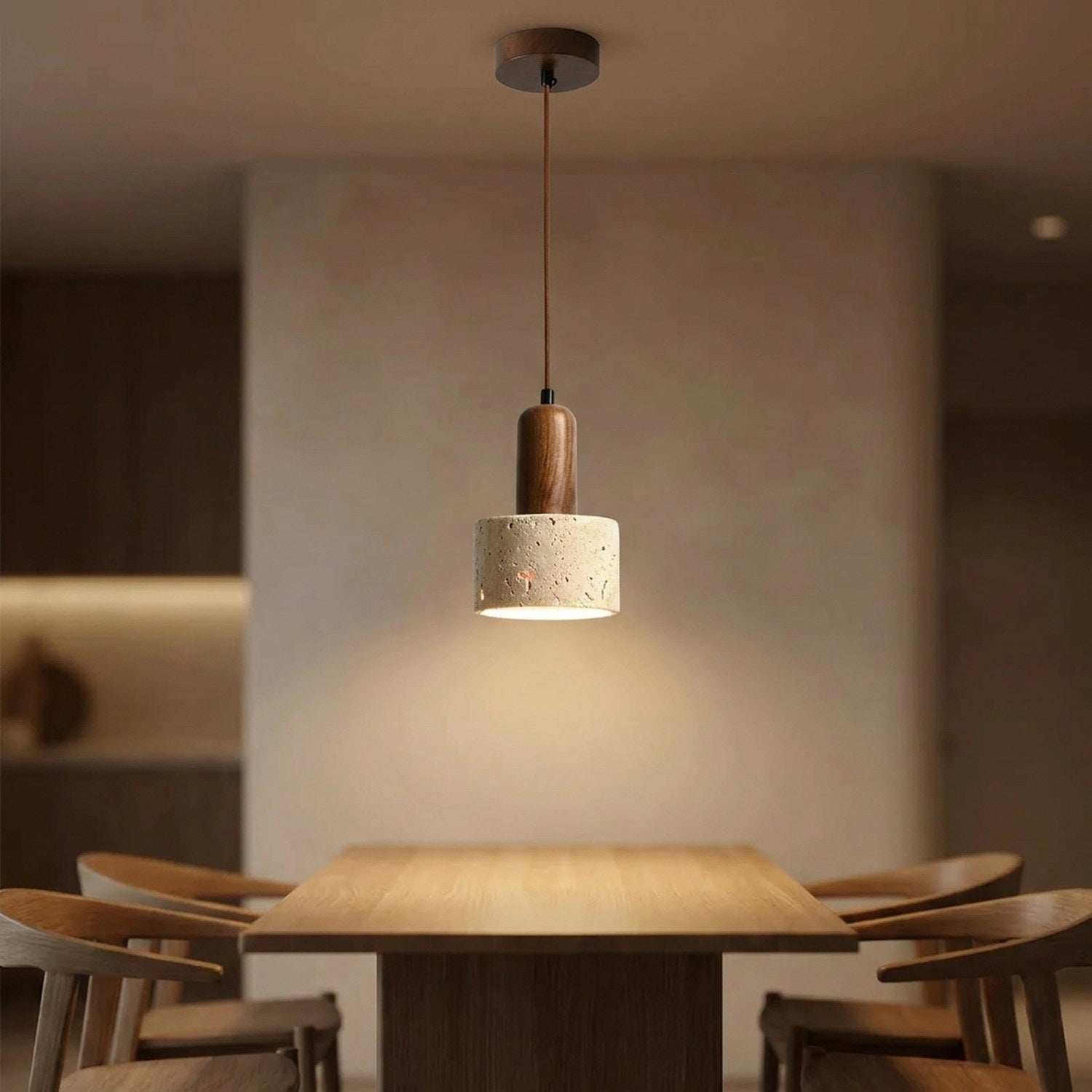 Suspension en travertin et bois noyer allumée au-dessus d'une table à manger