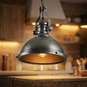 Suspension industrielle finition argentée antique allumée au-dessus d’un îlot de cuisine