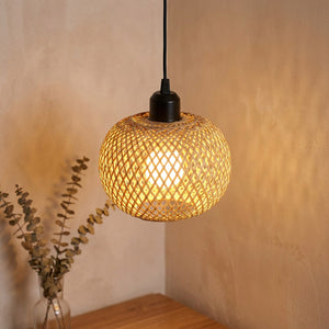 Suspension en bambou tressé à la main allumée diffusant une lumière dorée dans un intérieur chaleureux