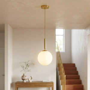 Suspension boule de verre dépoli en laiton dans une entrée moderne près d'un escalier