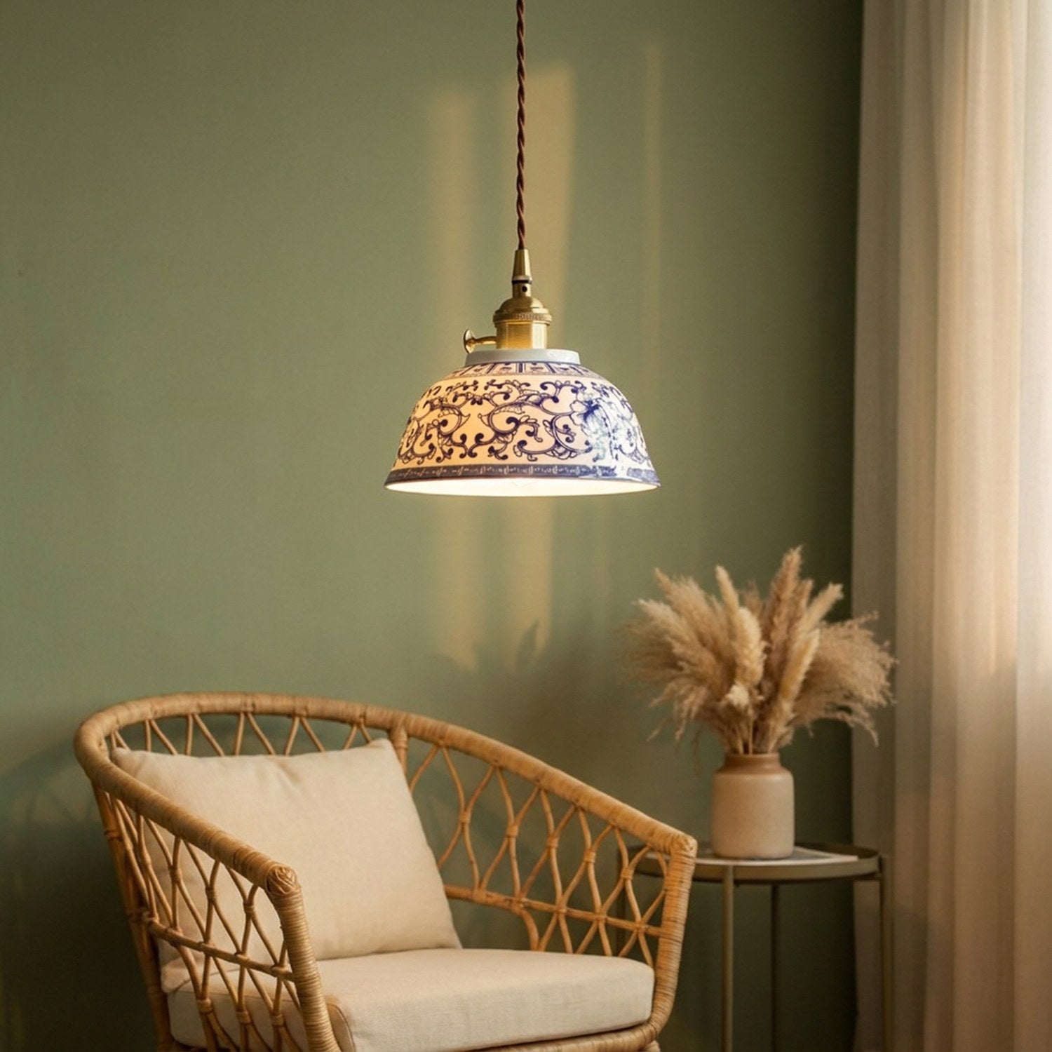 Suspension céramique éclairée dans un coin salon avec fauteuil en rotin