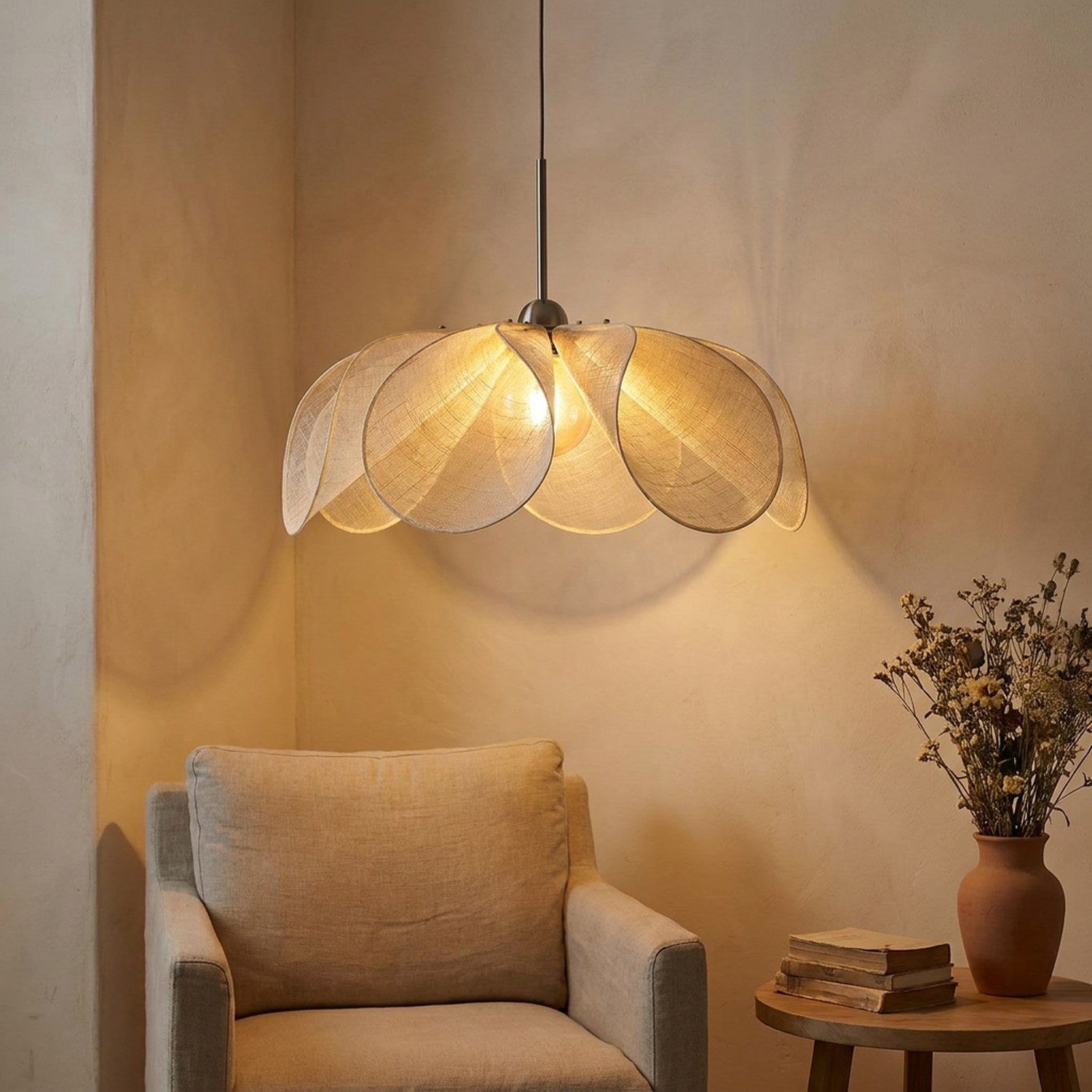 Suspension pétales de tissu illuminant un coin lecture fauteuil beige et bouquet séché