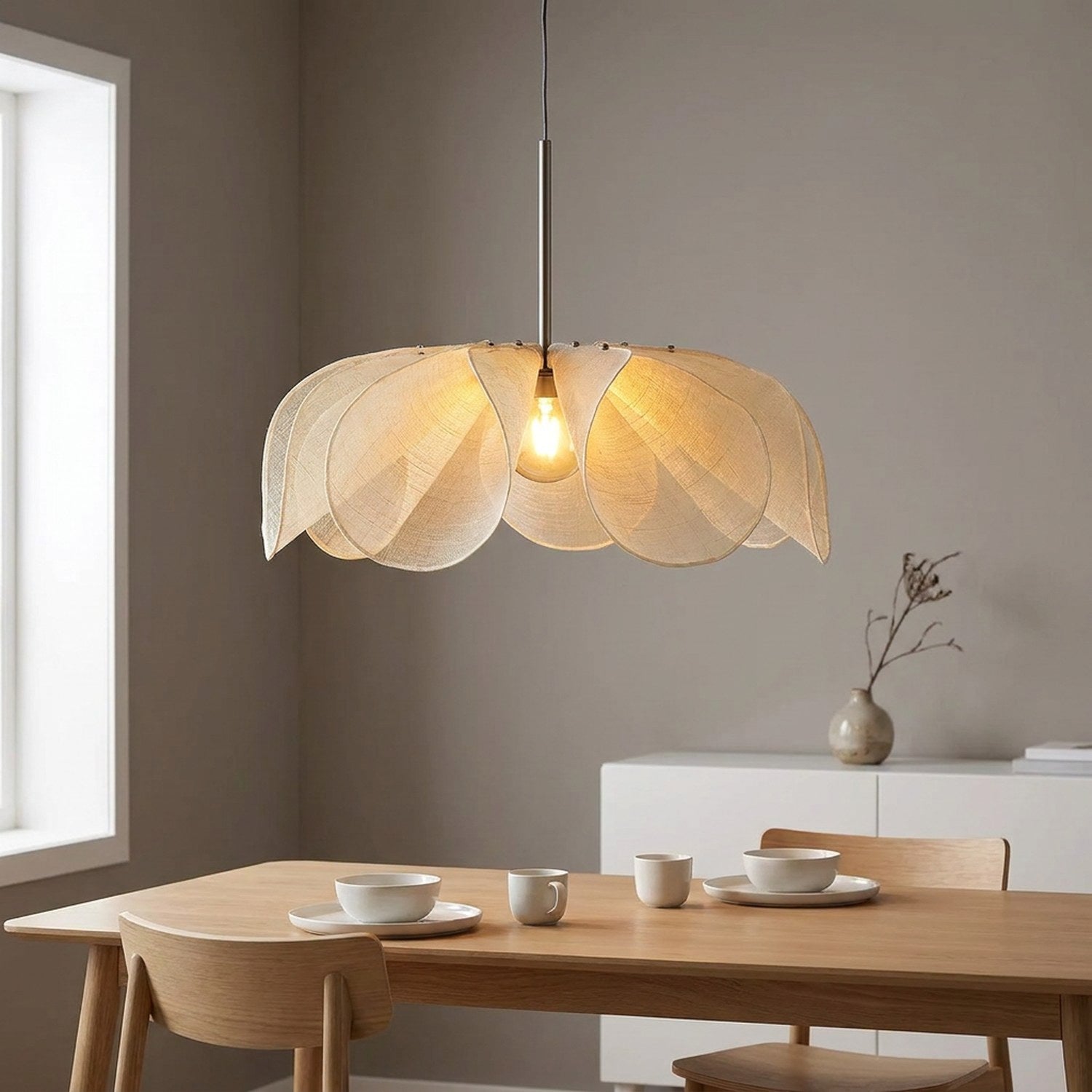 Suspension pétales de tissu au-dessus d'une table à manger scandinave en bois clair