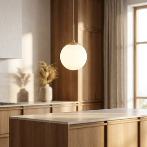 Suspension globe doré allumée au-dessus d'un îlot de cuisine moderne